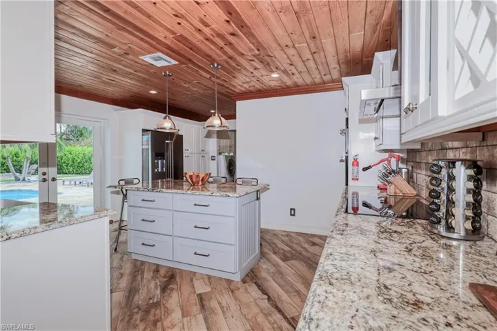 Kitchen featuring high end fridge, white cabinetry, and light wood plank tile flooring