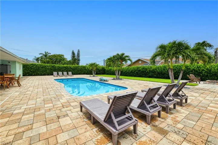 View of pool with a patio area and a lawn