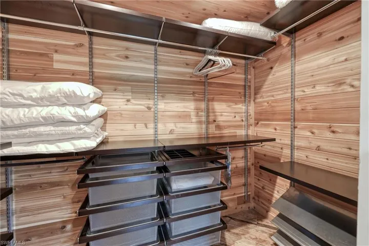 Walk in cedar lined closet featuring wood plank tile flooring