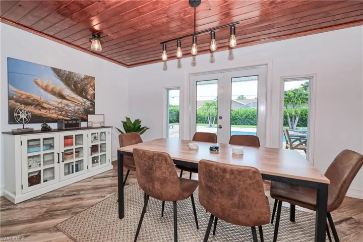 Dining room w/wood plank tile floors, wood ceiling, french doors, and track lighting