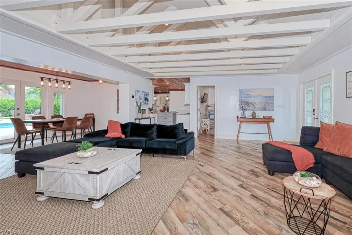 Living room featuring french doors, wood plank tile flooring, and beam ceiling