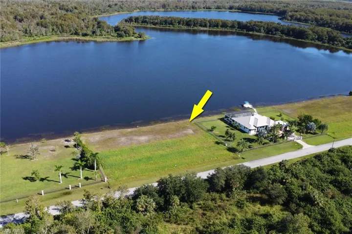 Drone / aerial view of a nearby body of water and a forest