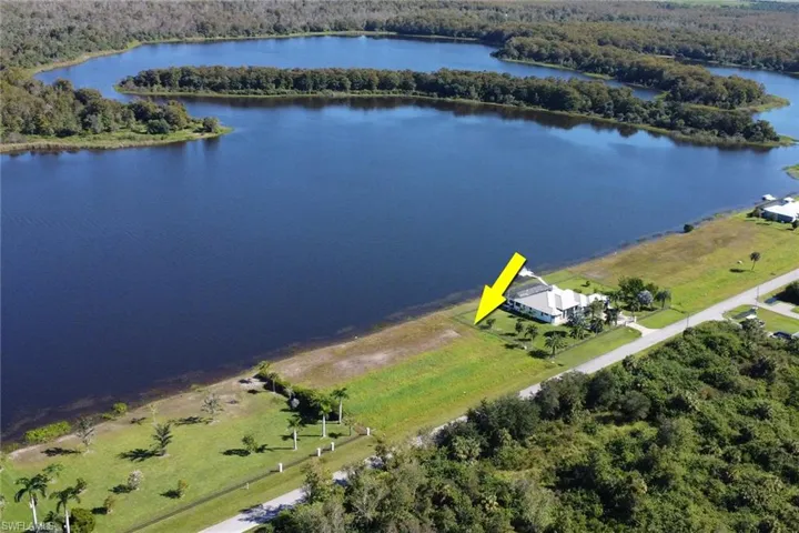 Drone / aerial view of a heavily wooded area and a large body of water