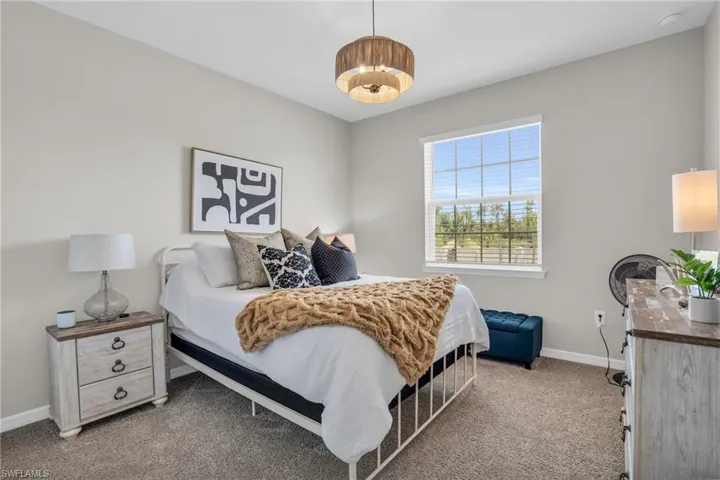 Bedroom with light carpet and baseboards