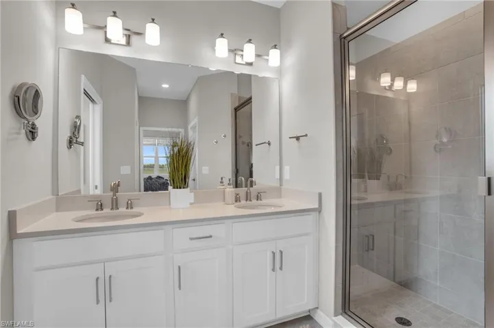 Ensuite bathroom with a sink, ensuite bathroom, double vanity, and a stall shower