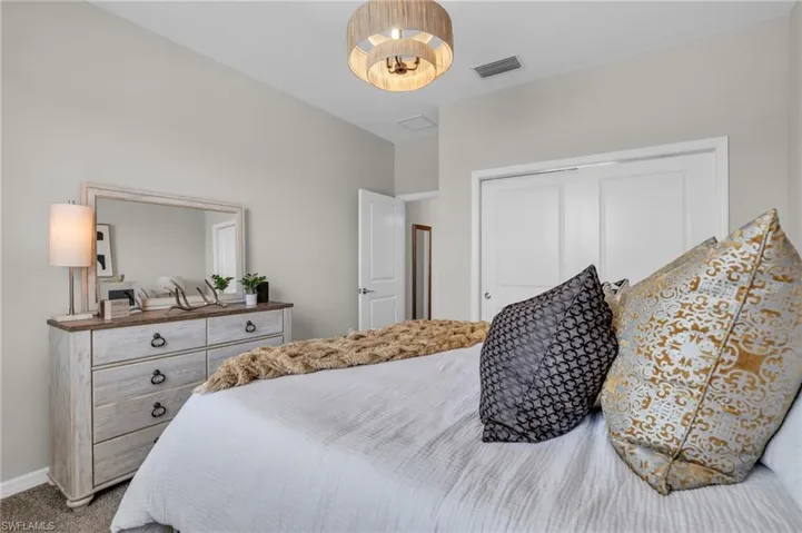 Bedroom featuring visible vents, baseboards, a closet, and carpet