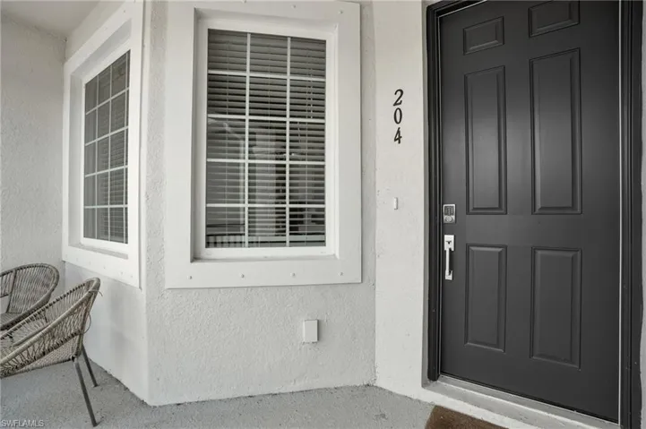 Doorway to property featuring stucco siding