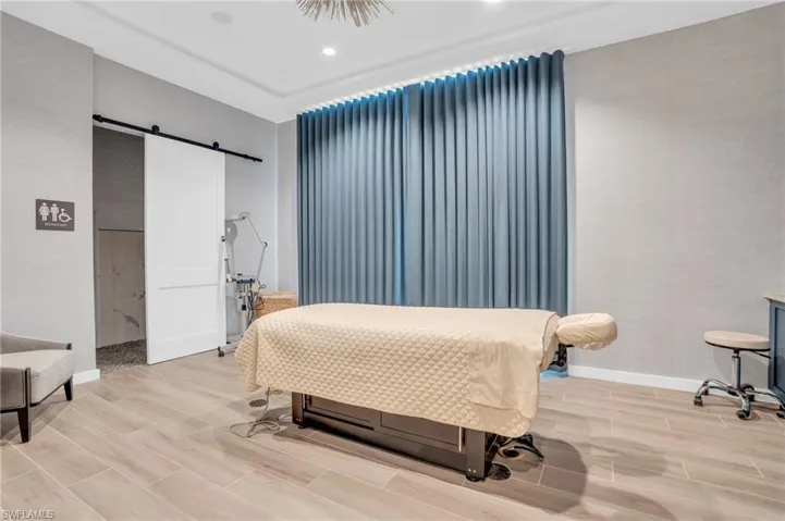 Bedroom with baseboards, wood tiled floor, recessed lighting, and a barn door