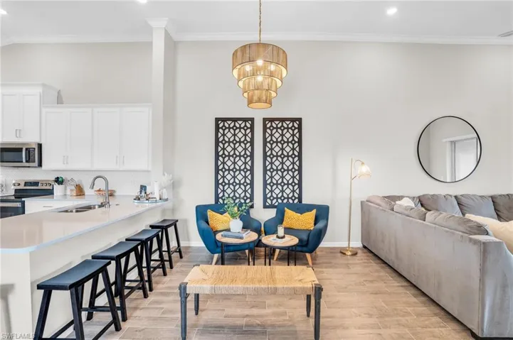 Living room with ornamental molding, light wood finished floors, and recessed lighting