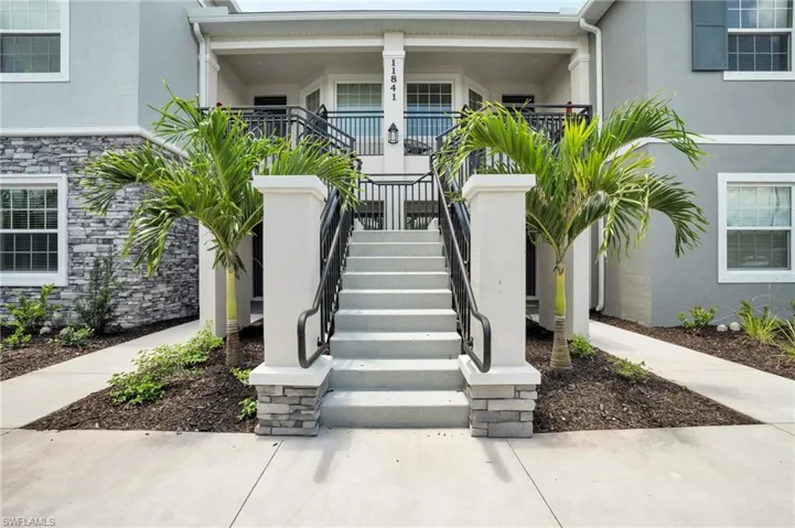 Property entrance featuring stone siding and stucco siding