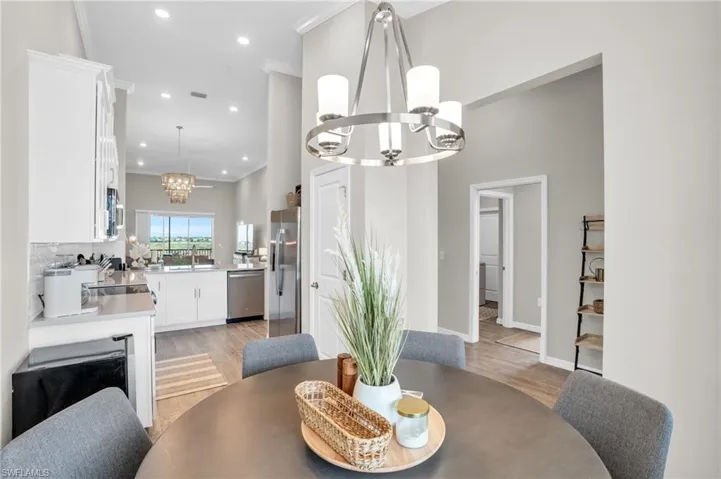 Dining room with crown molding, recessed lighting, a chandelier, and light wood finished floors