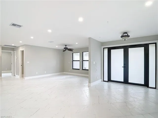 Unfurnished room featuring french doors, light tile flooring, and ceiling fan
