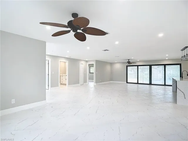 Empty room with sink, ceiling fan, and light tile floors