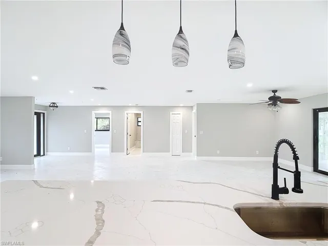 Living room featuring a wealth of natural light, sink, and ceiling fan