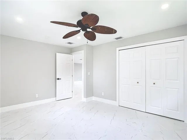 Unfurnished bedroom featuring a closet, ceiling fan, and light tile floors