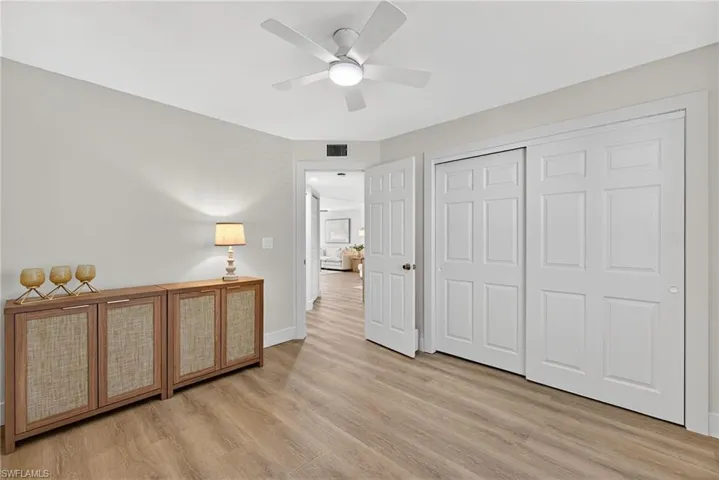 Bedroom with a closet, a ceiling fan, and light wood finished floors