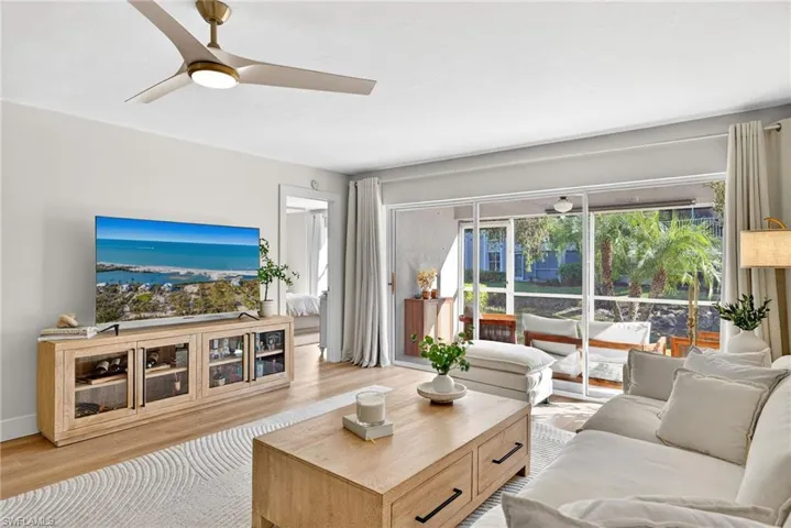 Living area with ceiling fan and wood finished floors