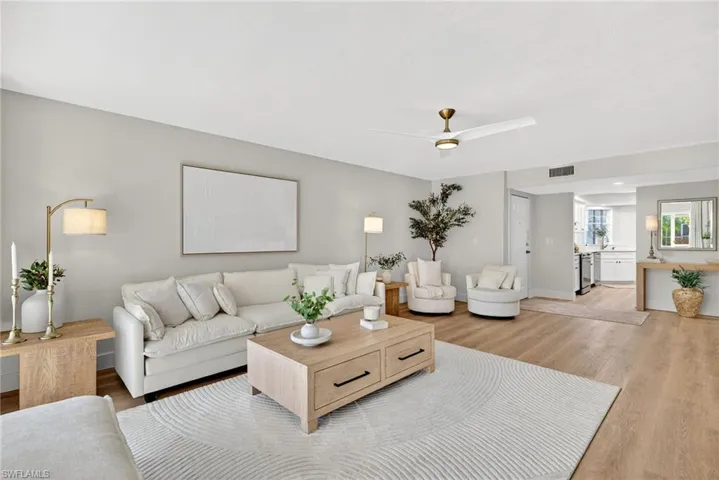 Living area with light wood-style floors and a ceiling fan