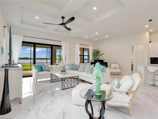 Living area with light marble finish flooring, coffered ceiling, ceiling fan, recessed lighting, and beamed ceiling