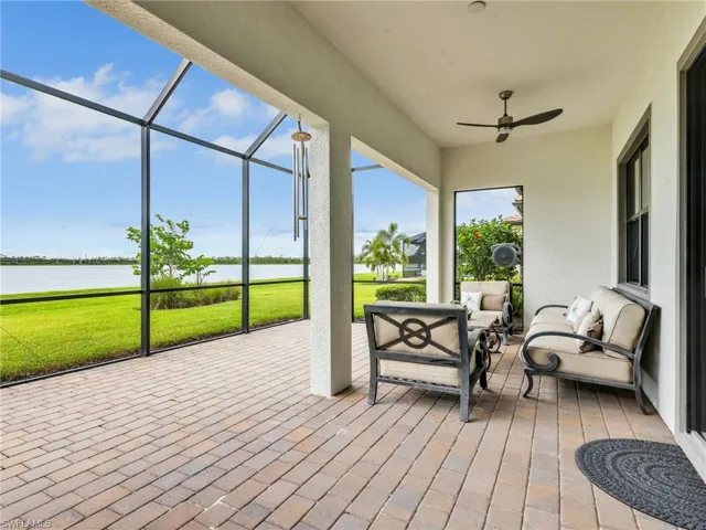 Sunroom / solarium with a water view, outdoor lounge area, a ceiling fan, and a patio area
