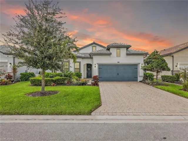Mediterranean / spanish-style house featuring a front lawn, decorative driveway, stucco siding, a tiled roof, and a garage