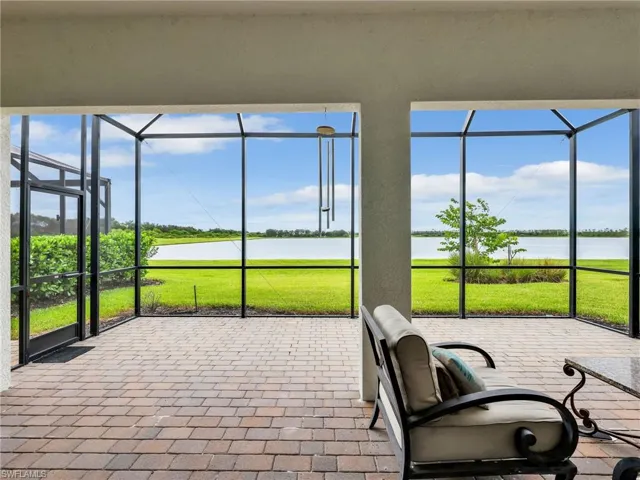 Sunroom / solarium with a water view and a patio