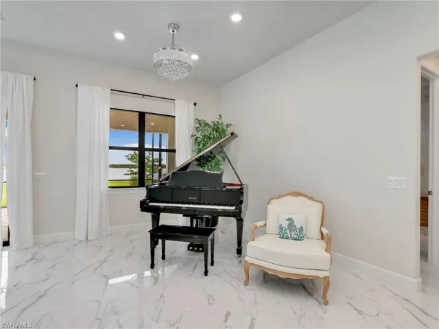Sitting room with marble tiled flooring, recessed lighting, and a chandelier