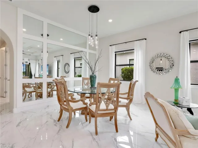 Dining space featuring marble tiled floors, recessed lighting, and arched walkways