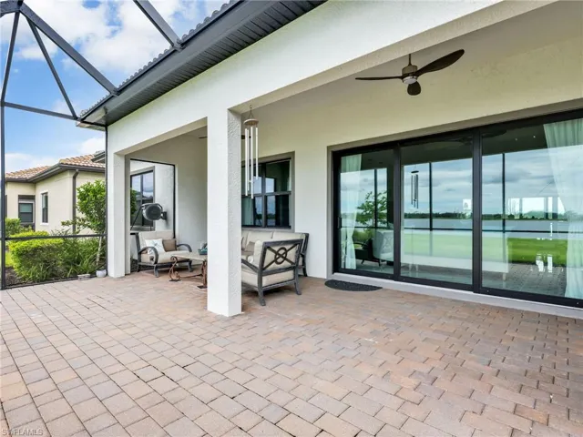 View of patio / terrace featuring a sunroom, a ceiling fan, glass enclosure, and an outdoor living space