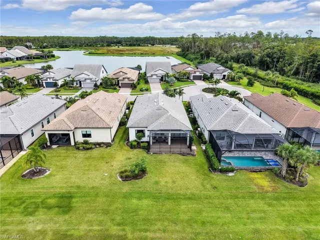 Aerial view of residential area featuring a large body of water and a pool