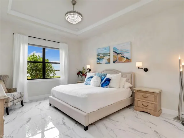 Bedroom featuring marble finish flooring and a raised ceiling