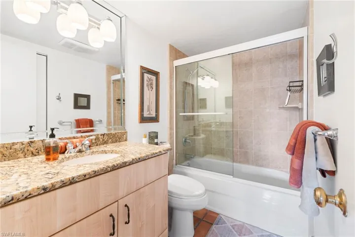 Full bathroom featuring vanity, shower / bath combination with glass door, and tile patterned floors