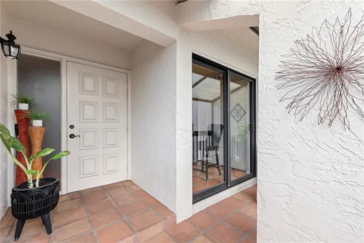 Doorway to property featuring stucco siding and a patio