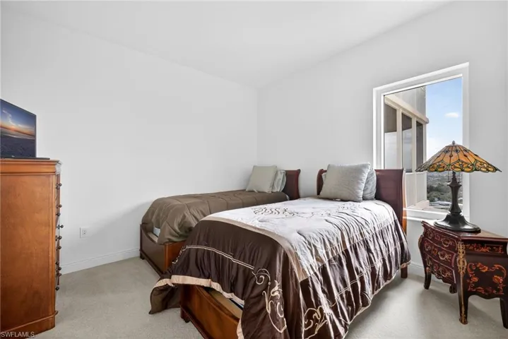 Bedroom featuring light colored carpet and baseboards