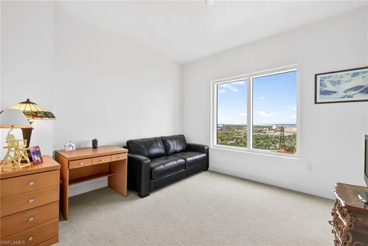 Living area featuring light colored carpet and baseboards