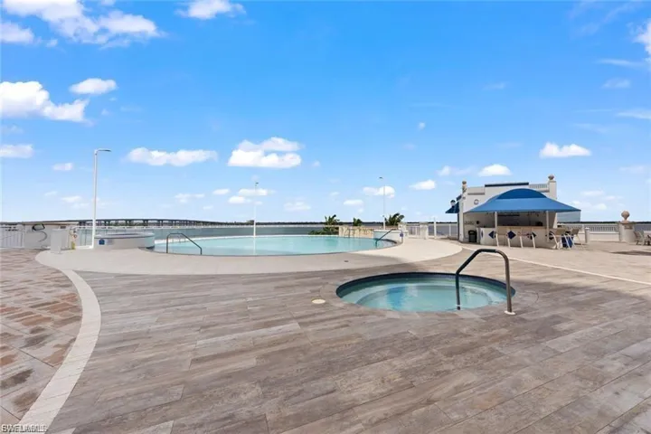 Community pool featuring a hot tub and a patio area