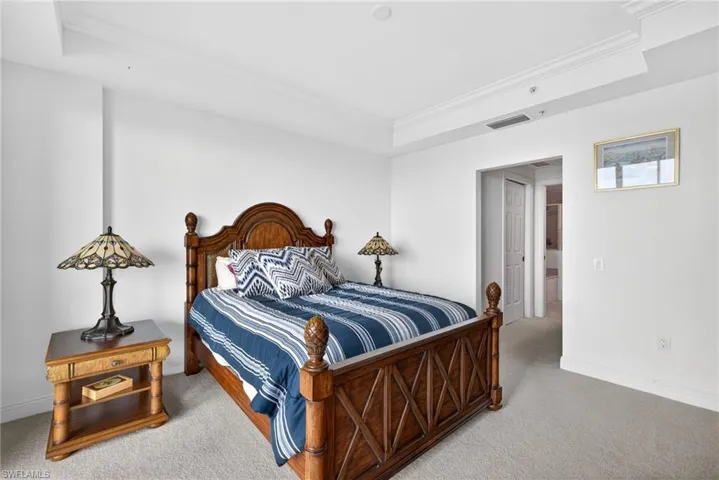 Bedroom with crown molding, a tray ceiling, and carpet flooring
