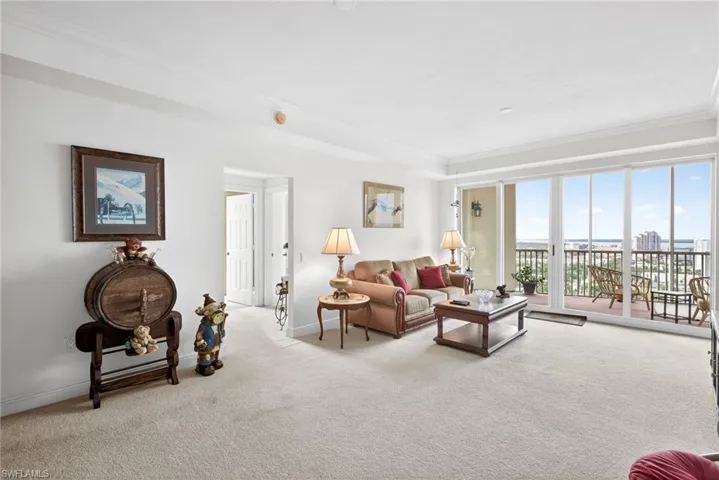 Living room featuring light colored carpet and crown molding