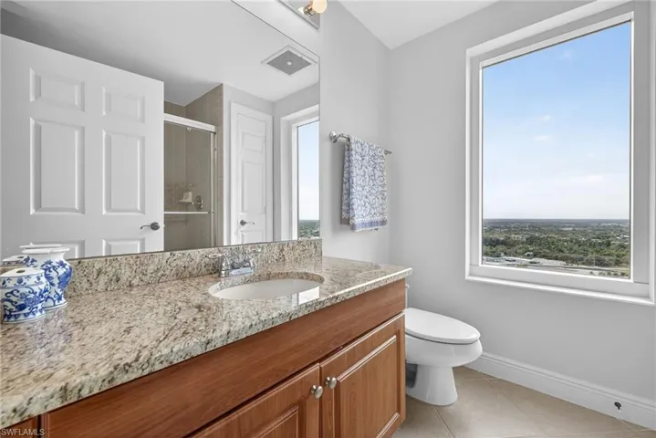 Bathroom with vanity, a shower stall, and light tile patterned floors