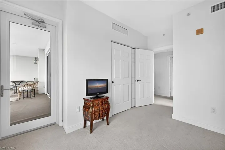 Bedroom featuring light carpet and a closet