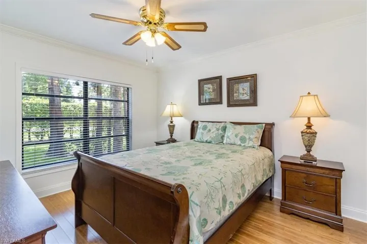 Bedroom featuring bamboo floors, ceiling fan, and crown molding