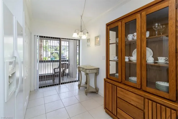 Dining area featuring ornamental molding, light tile patterned flooring, and an inviting chandelier