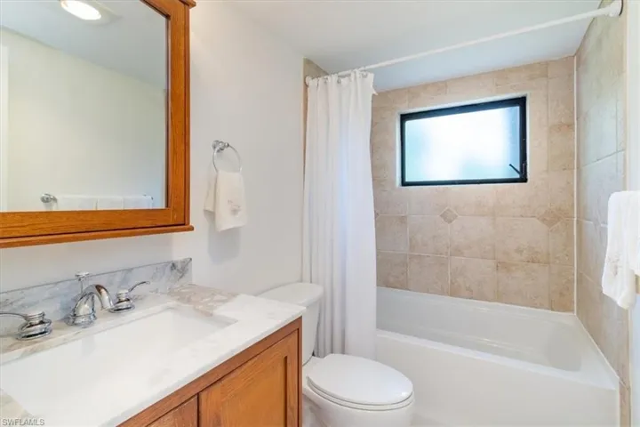 Full bathroom featuring toilet, vanity, and shower / tub combo with curtain
