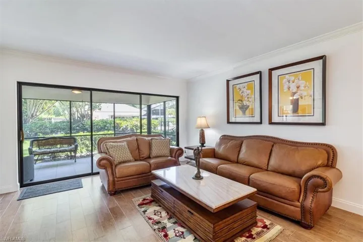 Living room with tile wood-like flooring and ornamental molding