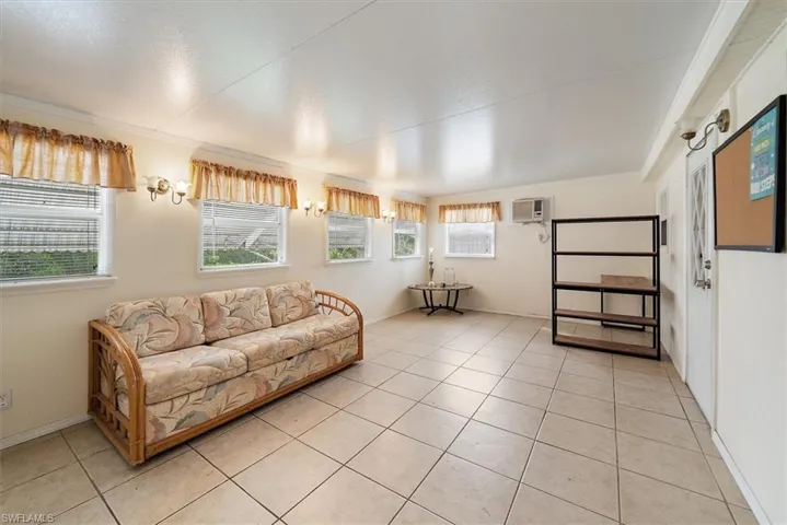 Living area with light tile patterned floors and ornamental molding