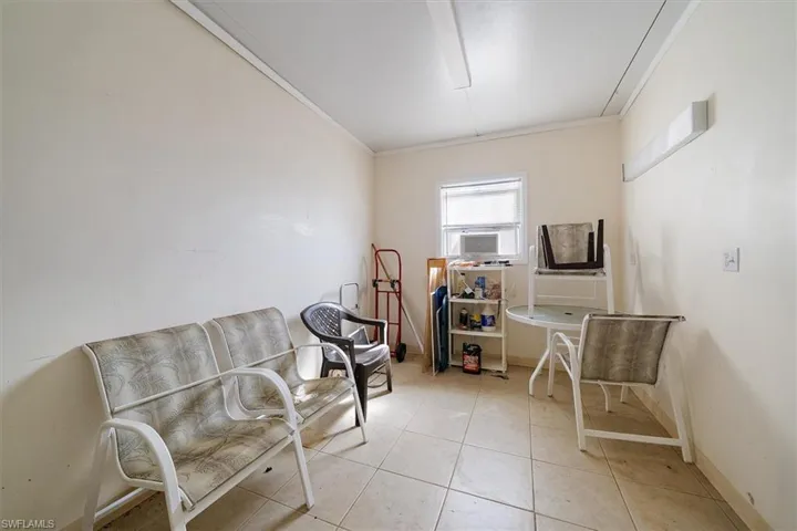 Sitting room with light tile patterned floors and crown molding