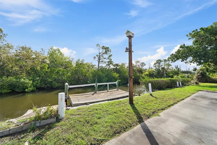 View of home's community with a water view and a dock
