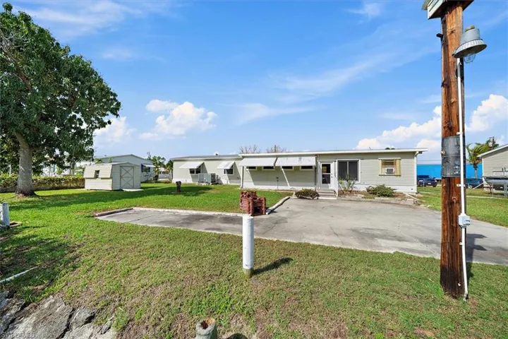 View of front facade with a front lawn, a patio area, a shed, and entry steps