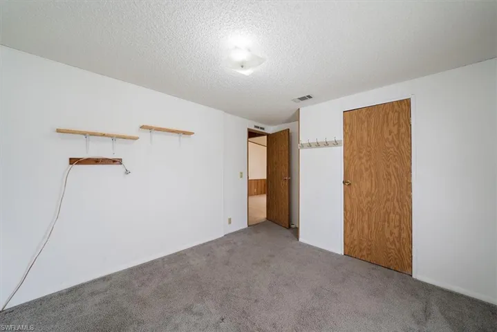 Unfurnished bedroom featuring a textured ceiling and carpet flooring