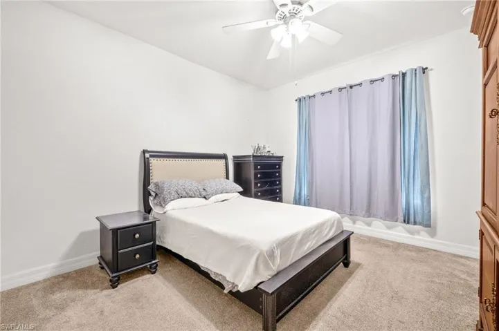 Bedroom featuring baseboards, ceiling fan, and carpet